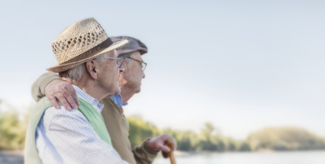 Two older men affected by metastatic pancreatic cancer sitting outside together.