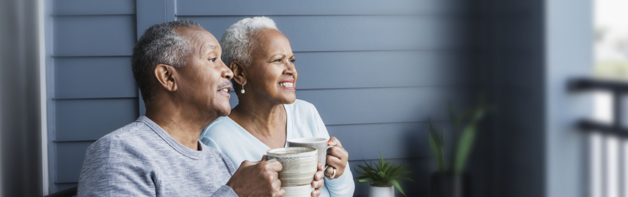 A couple affected by metastatic pancreatic cancer sitting on a porch having coffee.
