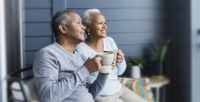 A couple affected by metastatic pancreatic cancer sitting on a porch having coffee.