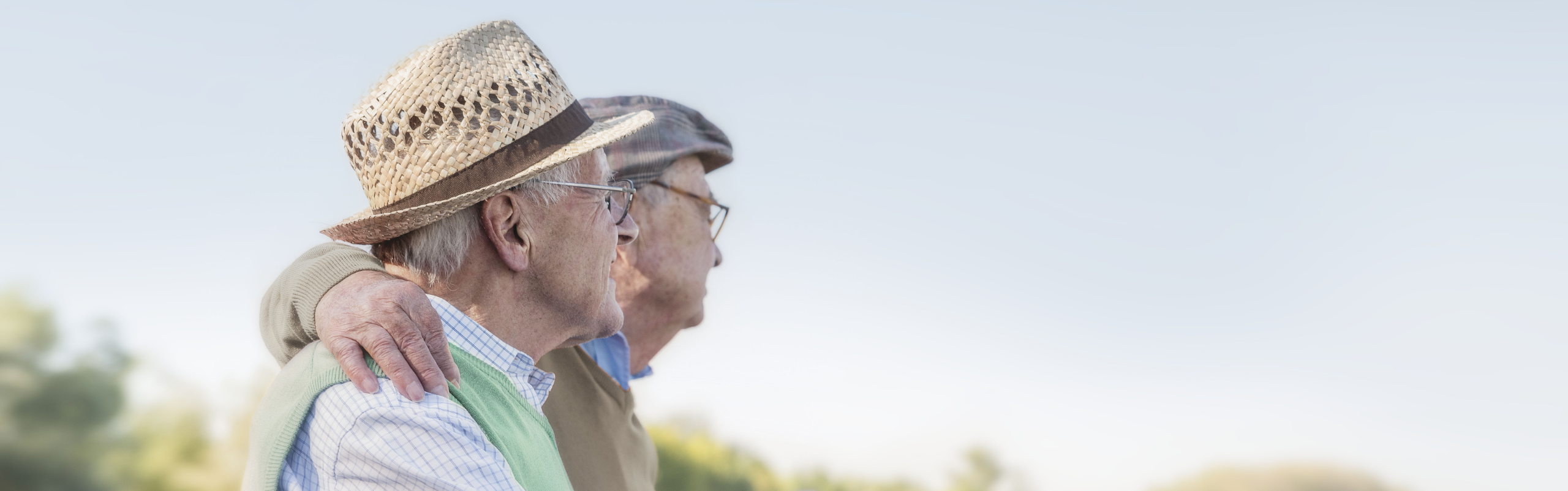 Two older men affected by metastatic pancreatic cancer sitting outside together.